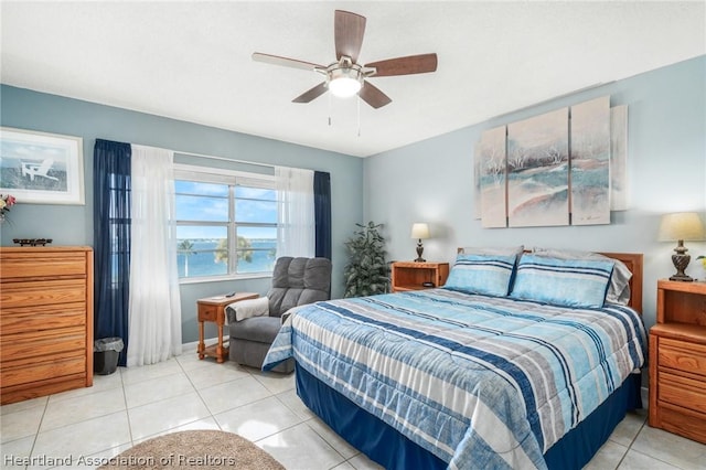 tiled bedroom with ceiling fan and a water view