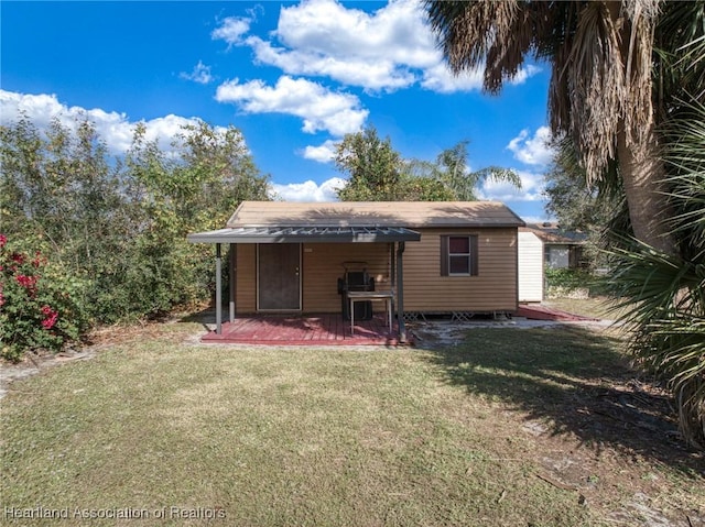 rear view of property featuring a lawn