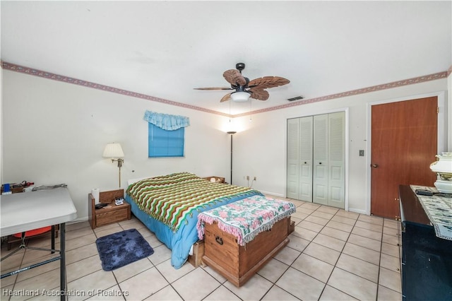 bedroom featuring ceiling fan, light tile patterned floors, and a closet