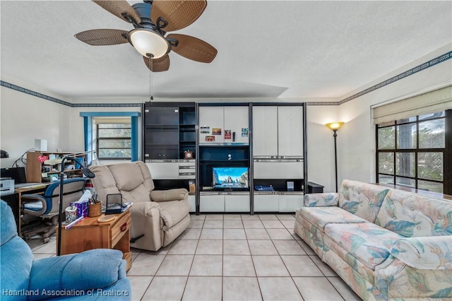 living room featuring ceiling fan, light tile patterned floors, and a textured ceiling