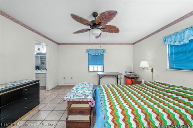 tiled bedroom featuring ensuite bathroom, ceiling fan, and ornamental molding