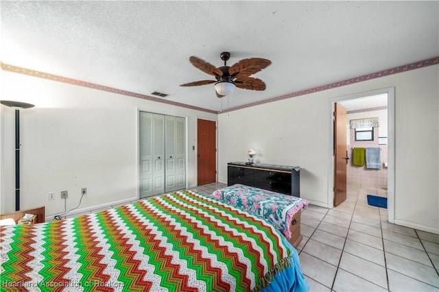 bedroom featuring light tile patterned floors, a textured ceiling, a closet, and ceiling fan