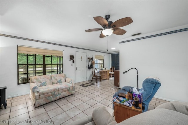 living room with ceiling fan, light tile patterned flooring, and ornamental molding