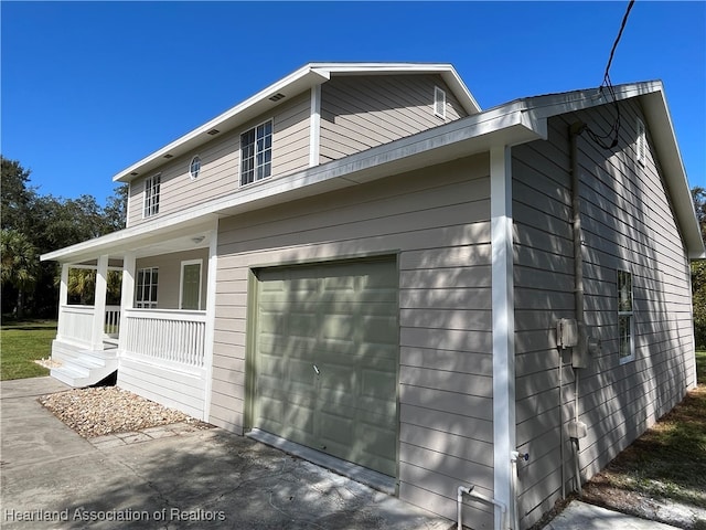 view of side of home with covered porch and a garage