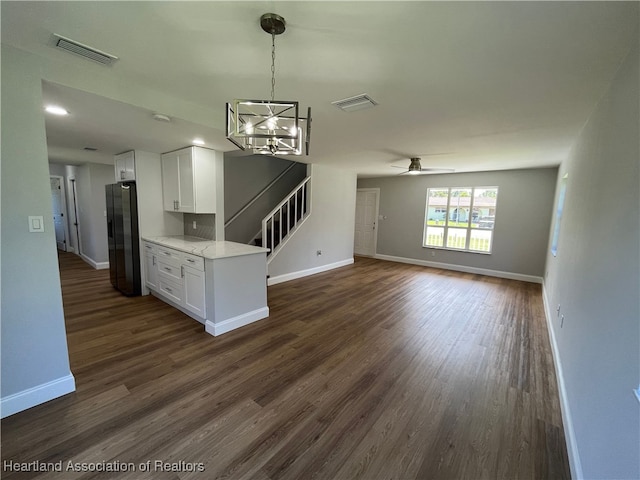 kitchen with white cabinets, ceiling fan with notable chandelier, dark hardwood / wood-style floors, light stone counters, and fridge with ice dispenser