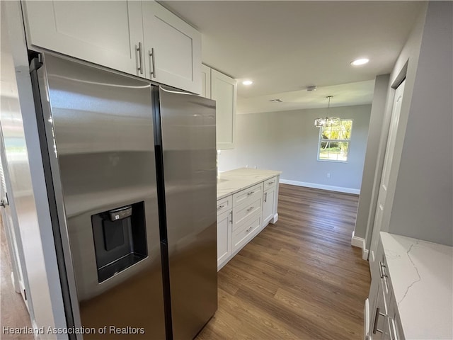 kitchen featuring light hardwood / wood-style floors, white cabinetry, light stone counters, and stainless steel fridge with ice dispenser