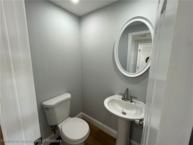 bathroom with hardwood / wood-style flooring, sink, and toilet