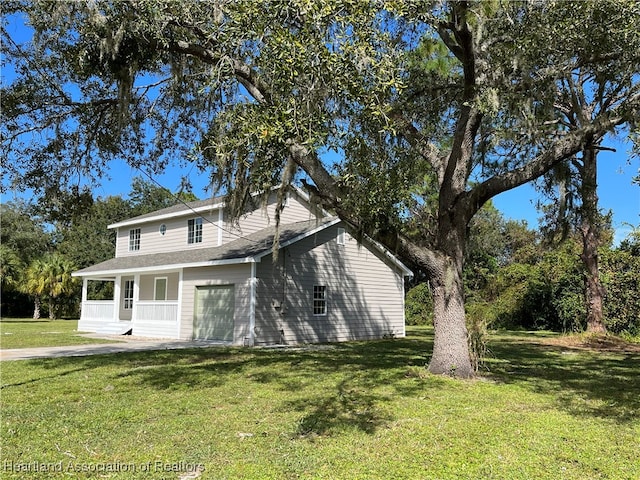 view of front of home featuring a porch, a garage, and a front lawn