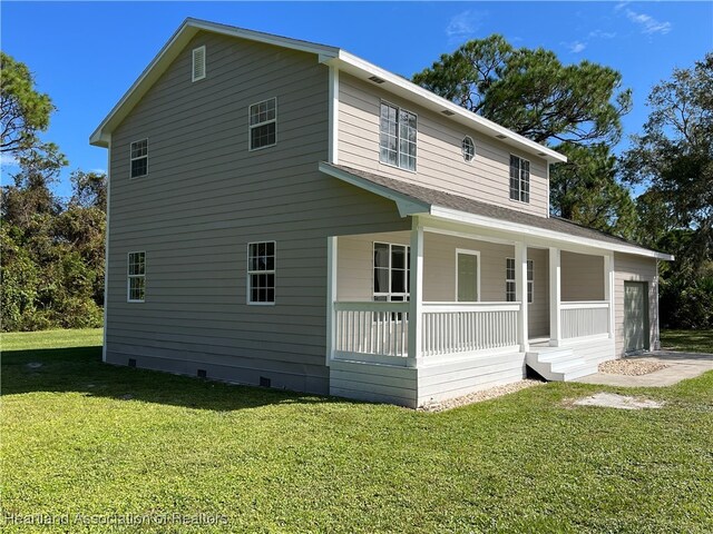 view of front of home with a porch, a garage, and a front lawn