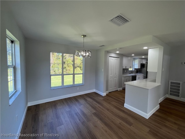 kitchen featuring sink, dark wood-type flooring, kitchen peninsula, a chandelier, and white cabinets