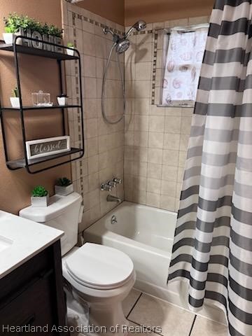 full bathroom with tile patterned floors, vanity, shower / bath combination with curtain, and toilet