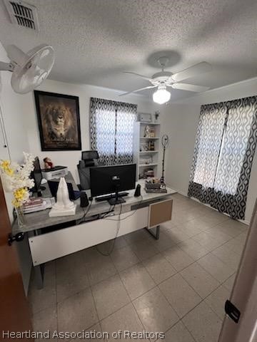 home office featuring ceiling fan and a textured ceiling