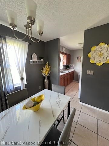 unfurnished dining area featuring light tile patterned floors and a textured ceiling