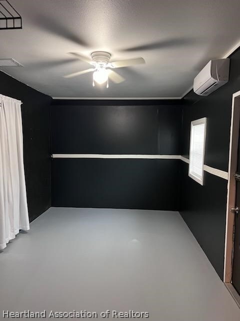 empty room featuring concrete flooring, an AC wall unit, and ceiling fan