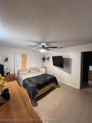 bedroom with ceiling fan and a textured ceiling