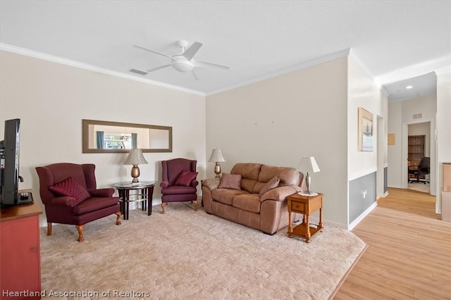 living room featuring ceiling fan, light hardwood / wood-style floors, and crown molding