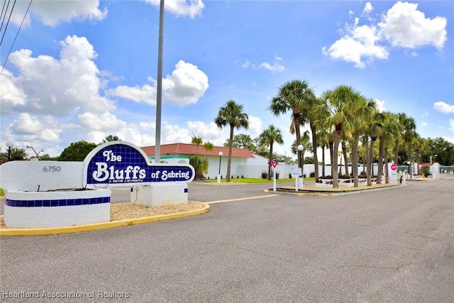 view of street featuring traffic signs, curbs, and a gated entry