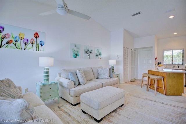 living area featuring a ceiling fan, visible vents, lofted ceiling, recessed lighting, and light carpet