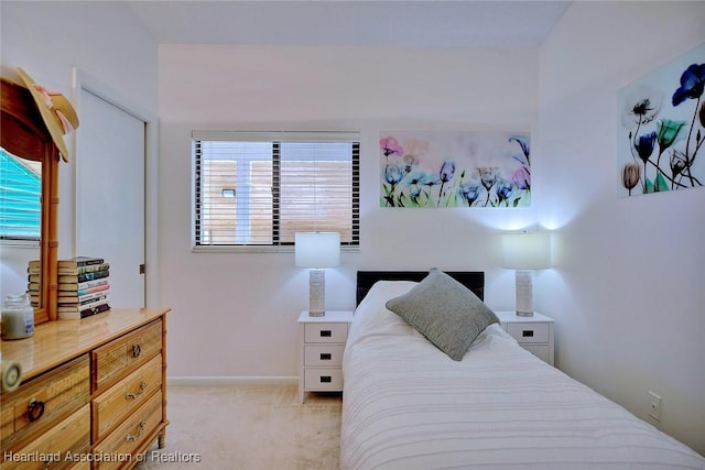 bedroom featuring baseboards and light carpet