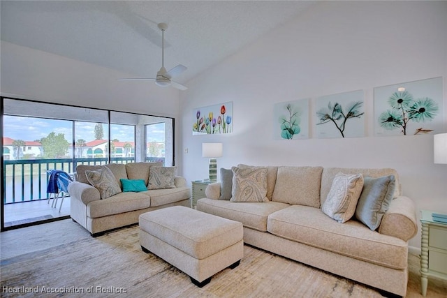 living area featuring high vaulted ceiling and ceiling fan