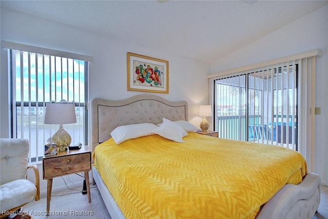 carpeted bedroom featuring multiple windows, lofted ceiling, and access to exterior