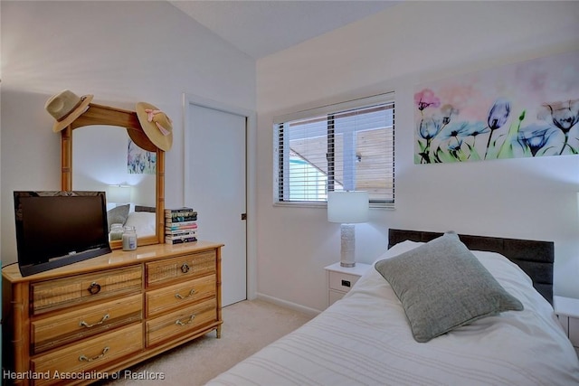 bedroom with baseboards and light colored carpet