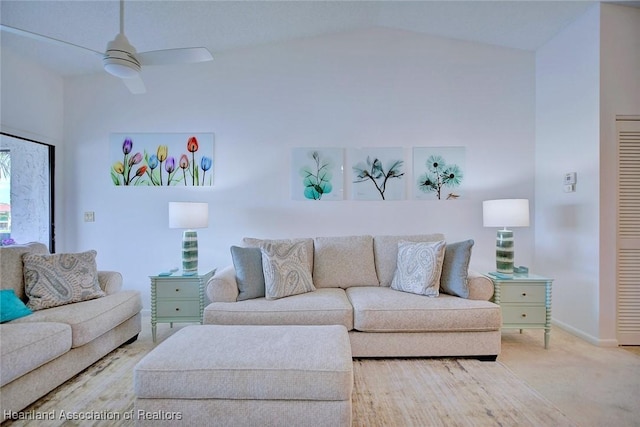 living area featuring baseboards, lofted ceiling, carpet floors, and a ceiling fan