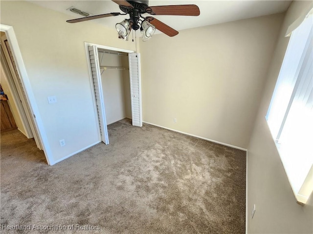 unfurnished bedroom with ceiling fan, light carpet, and a closet