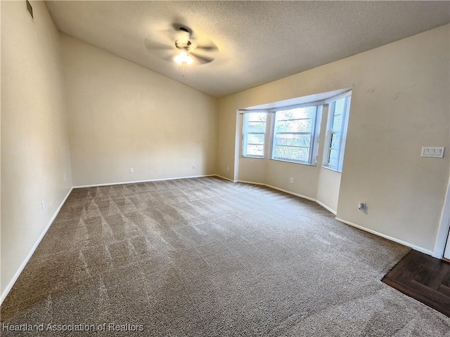 carpeted spare room featuring ceiling fan and a textured ceiling