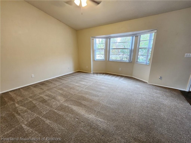 spare room with carpet, vaulted ceiling, and ceiling fan