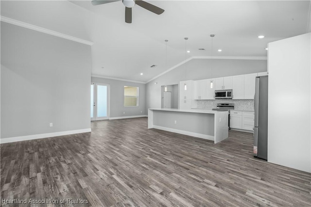 kitchen with decorative backsplash, appliances with stainless steel finishes, a kitchen island, white cabinetry, and hanging light fixtures