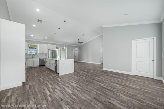 kitchen featuring backsplash, stainless steel appliances, a center island, white cabinetry, and hanging light fixtures