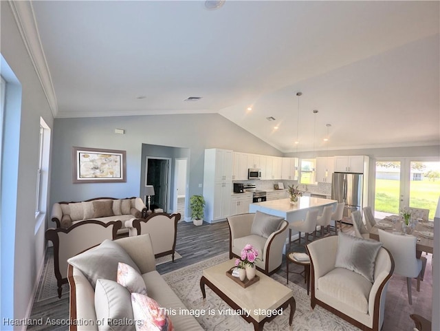 living room with light hardwood / wood-style flooring, vaulted ceiling, and ornamental molding