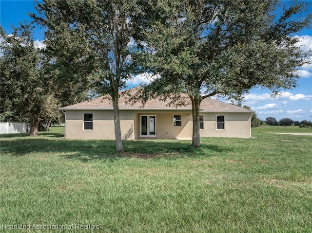 rear view of property with a lawn