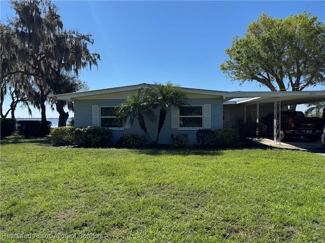 view of front of home featuring an attached carport and a front yard