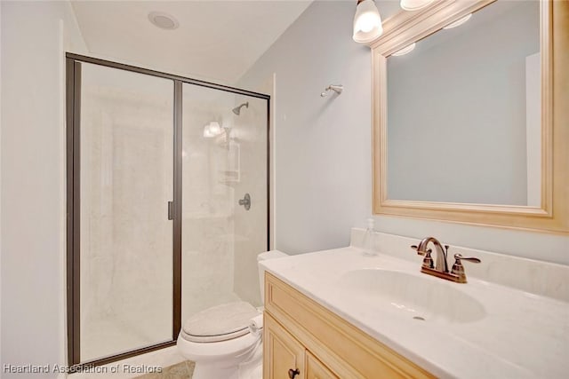 bathroom featuring vanity, an enclosed shower, and toilet