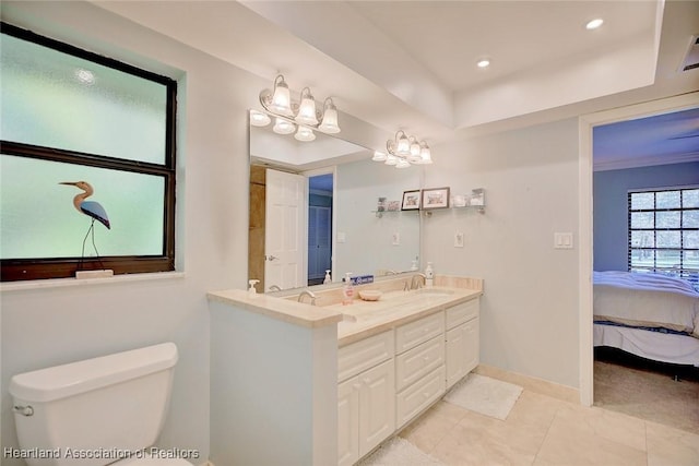 bathroom with toilet, a raised ceiling, vanity, and tile patterned floors