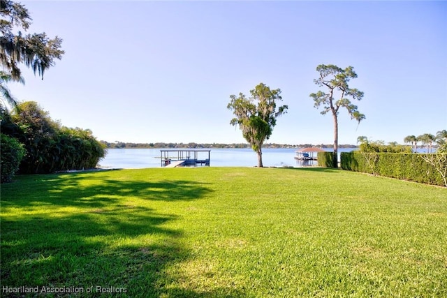 view of yard featuring a boat dock and a water view