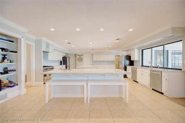 kitchen featuring a kitchen bar, crown molding, white cabinets, and appliances with stainless steel finishes