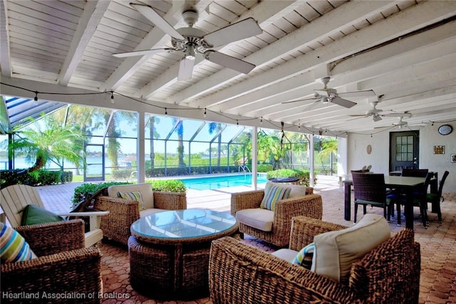 view of patio with an outdoor living space, ceiling fan, and a lanai