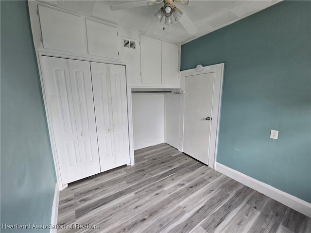 unfurnished bedroom with ceiling fan, a closet, and light wood-type flooring