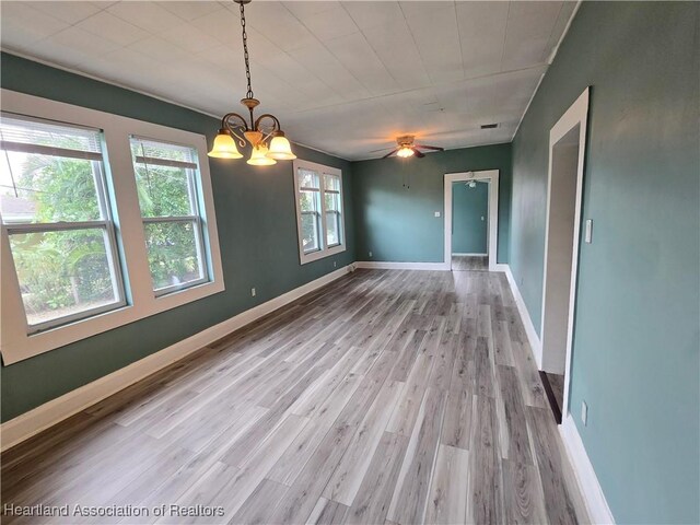 dining area featuring hardwood / wood-style floors, ceiling fan with notable chandelier, and a healthy amount of sunlight