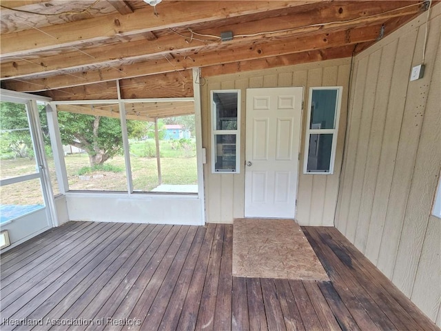 unfurnished sunroom featuring vaulted ceiling