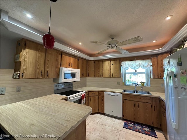 kitchen featuring sink, white appliances, backsplash, a textured ceiling, and a raised ceiling