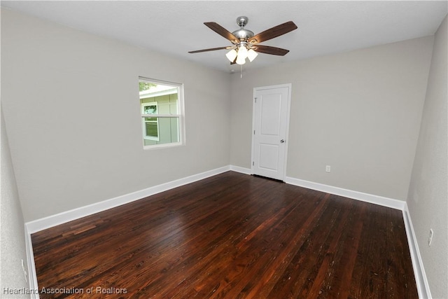 spare room with dark hardwood / wood-style floors and ceiling fan