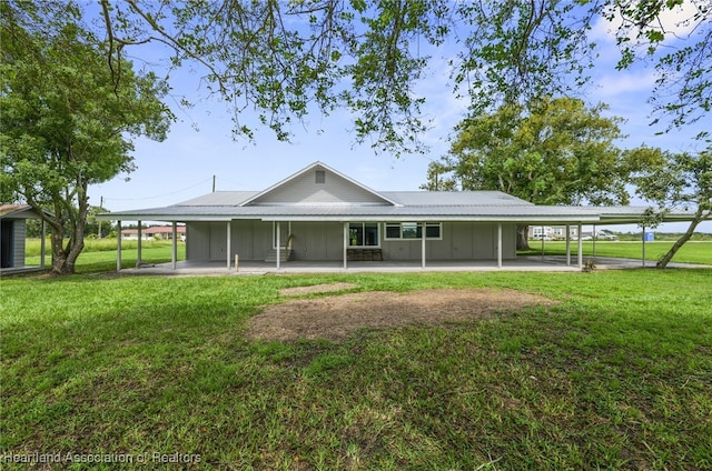 back of property featuring a lawn and a carport