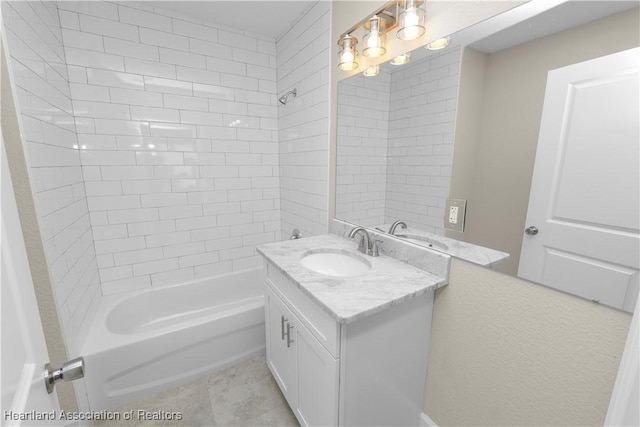 bathroom with tile patterned floors, vanity, and tiled shower / bath