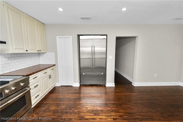 kitchen featuring premium appliances, tasteful backsplash, and dark wood-type flooring