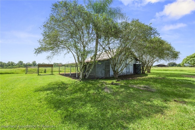 view of yard featuring a rural view and an outdoor structure