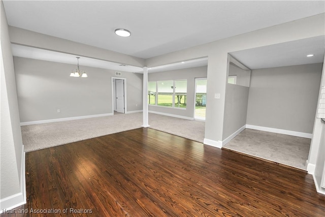 spare room with an inviting chandelier and hardwood / wood-style flooring